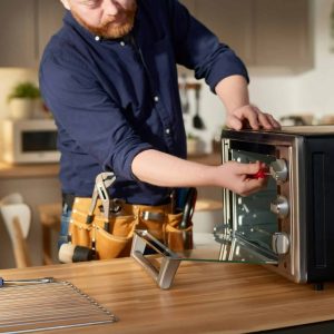 repairman-using-tools-to-fix-oven.jpg